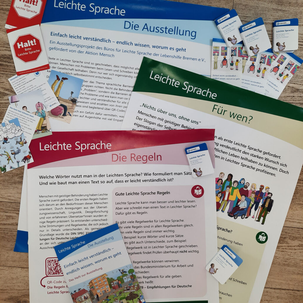 Beispiele für alle Materialien, die man für die Ausstellung kaufen kann: 3 Plakate, Postkarten, Info-Heft, Taschenplaner